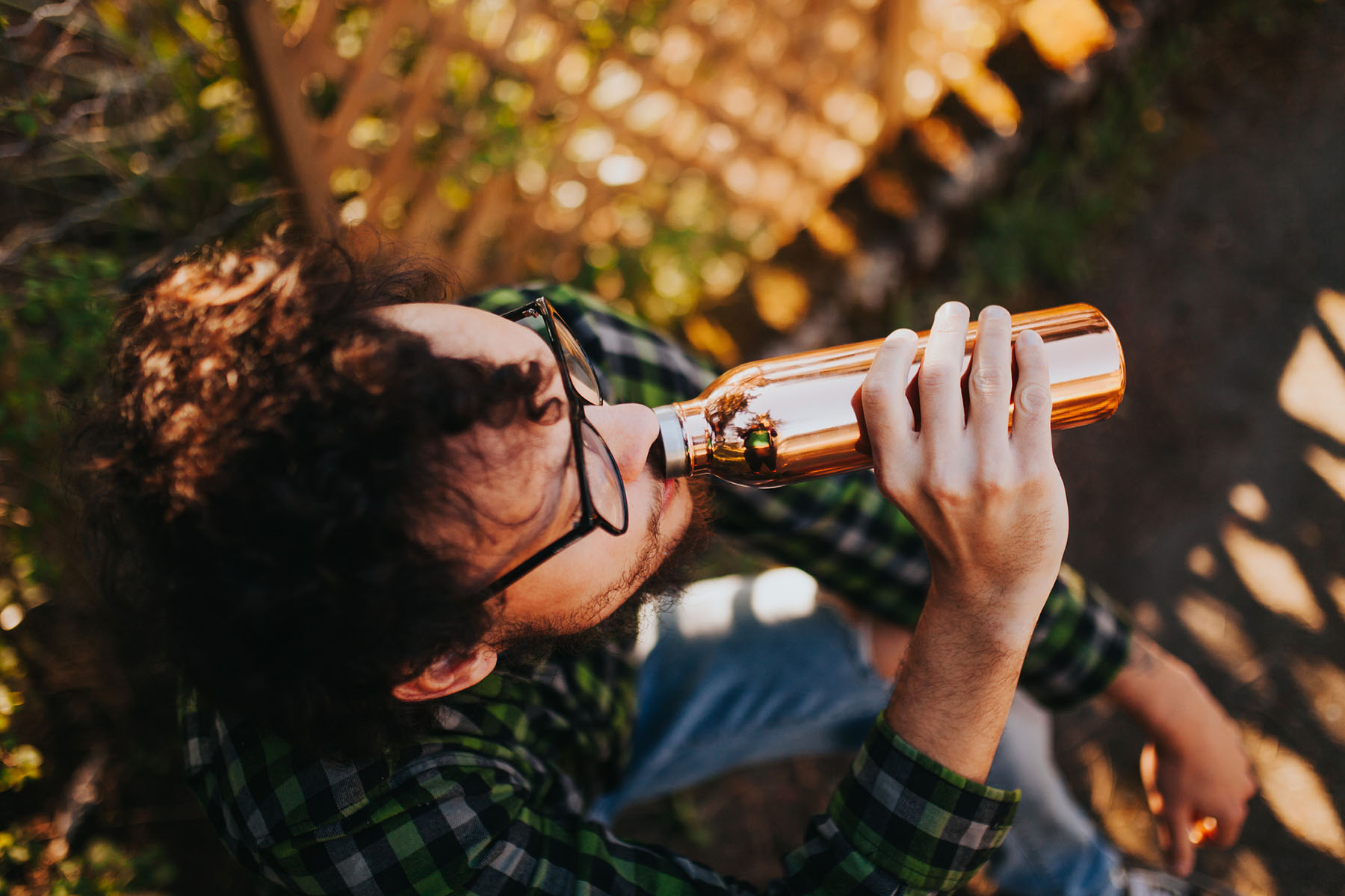 A man drinking from a refillable metal bottle